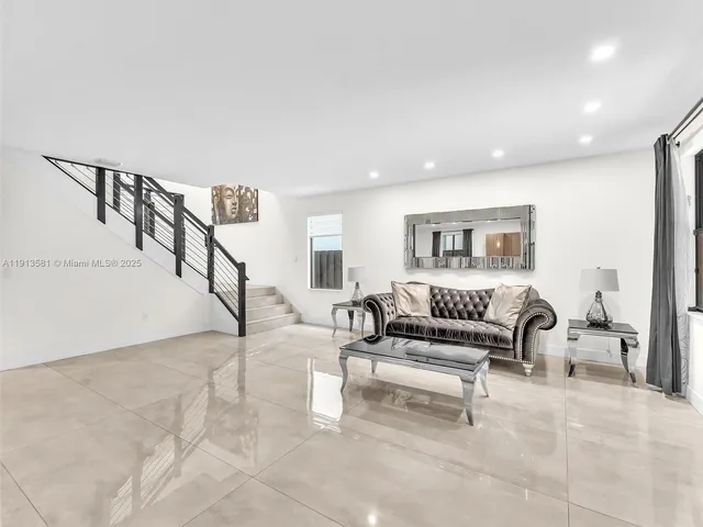 a living room with furniture and kitchen view