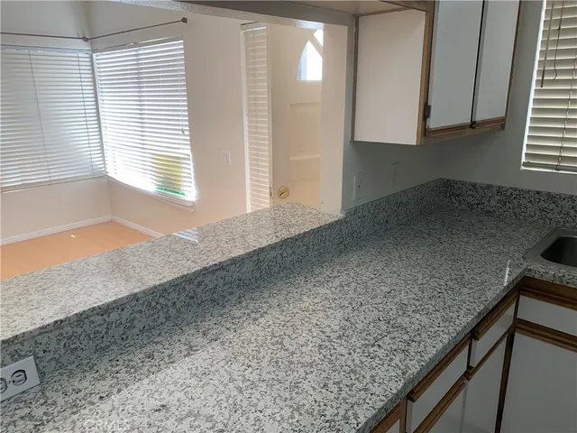 a kitchen with granite countertop sink and cabinets