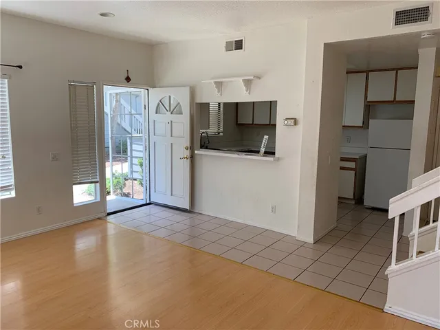 a view of a kitchen with refrigerator and window