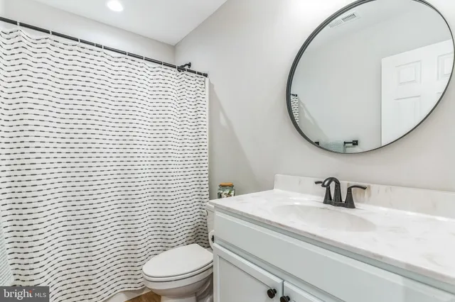 a bathroom with a sink a toilet and mirror