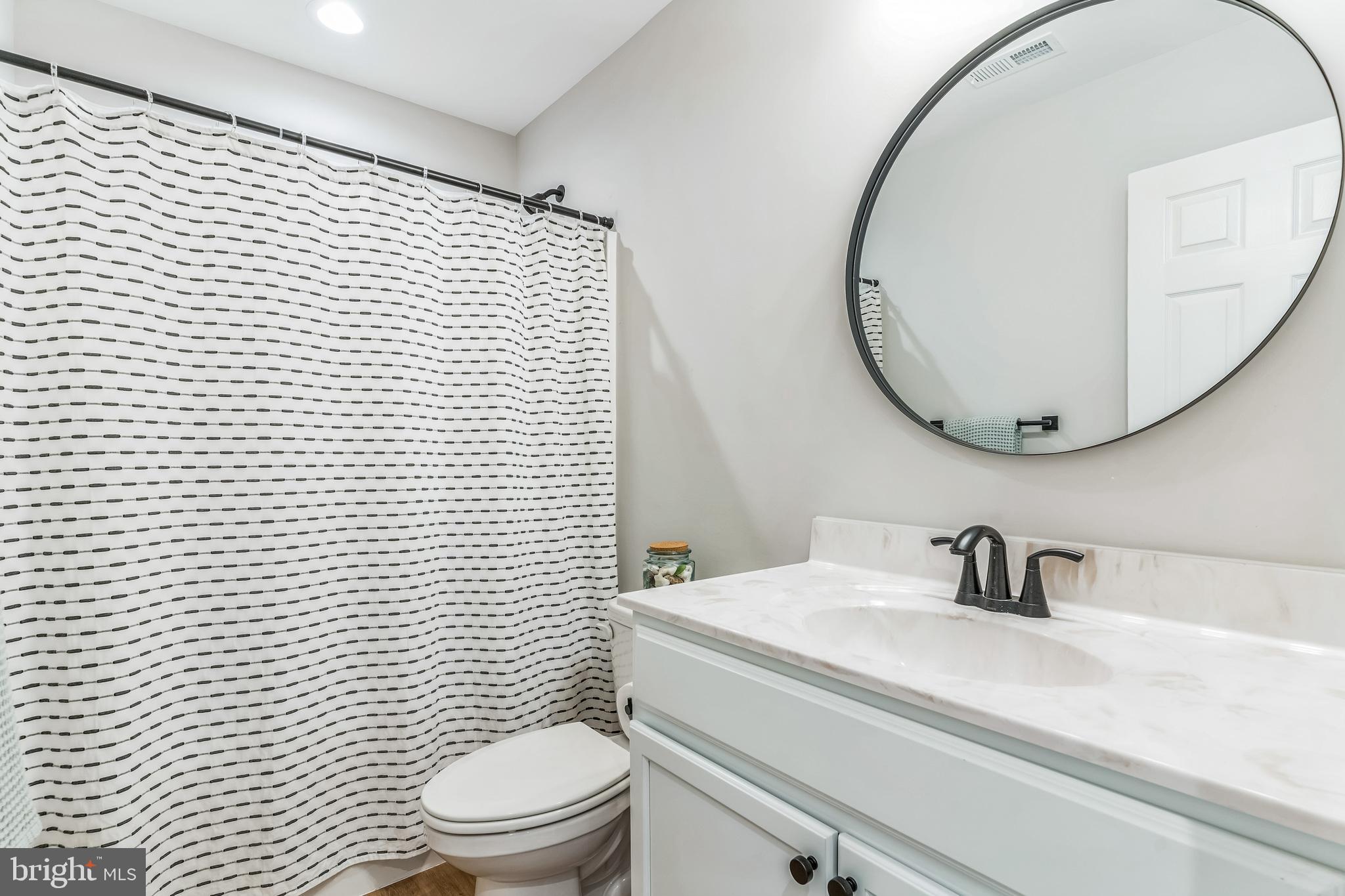 14720 Locust Court Issue, MD 20645 - Photo 20 of 42 a bathroom with a sink a toilet and mirror