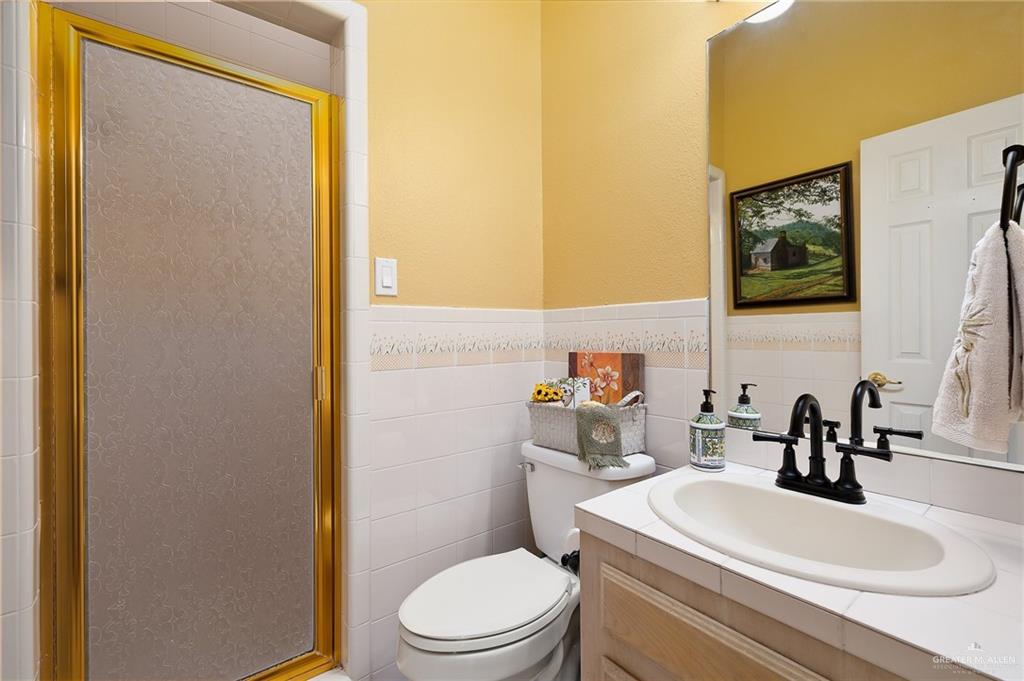 5344 East Mile 4 Road Mission, TX 78573 - Photo 17 of 22 a bathroom with a toilet a sink and mirror