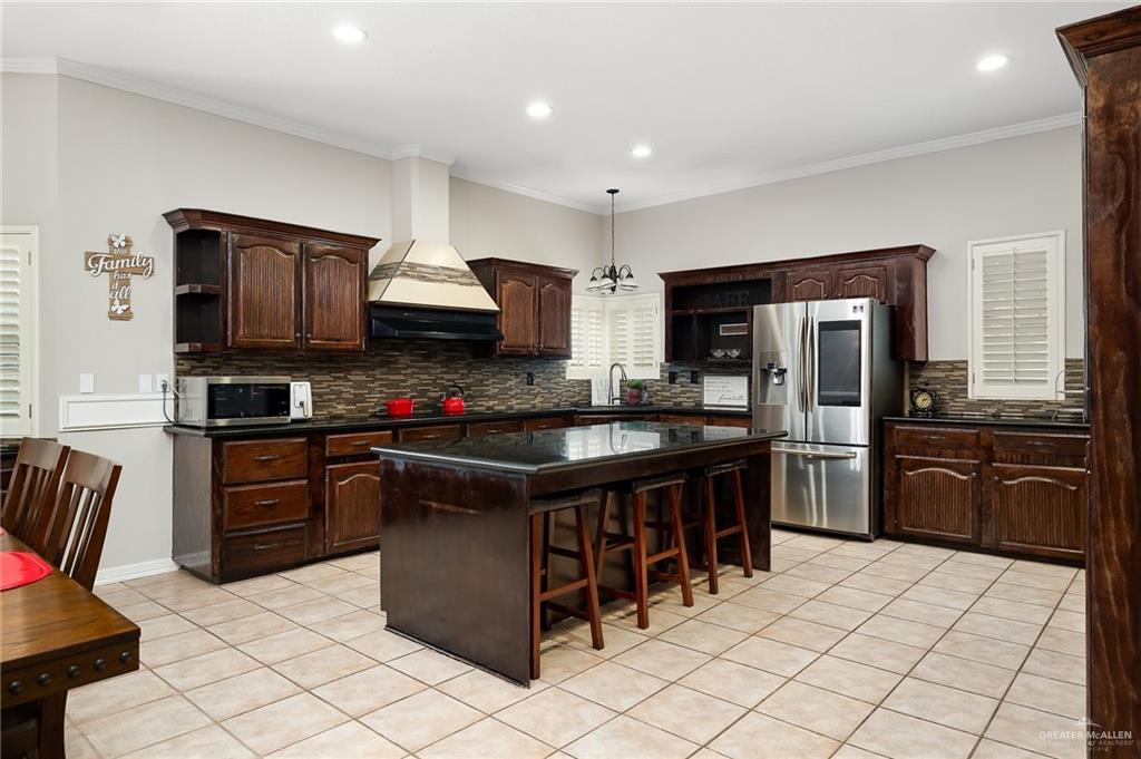 5344 East Mile 4 Road Mission, TX 78573 - Photo 9 of 22 a kitchen with stainless steel appliances granite countertop a stove top oven a sink dishwasher and a refrigerator