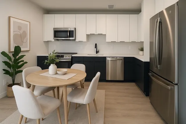 a kitchen with stainless steel appliances a table chairs microwave and refrigerator