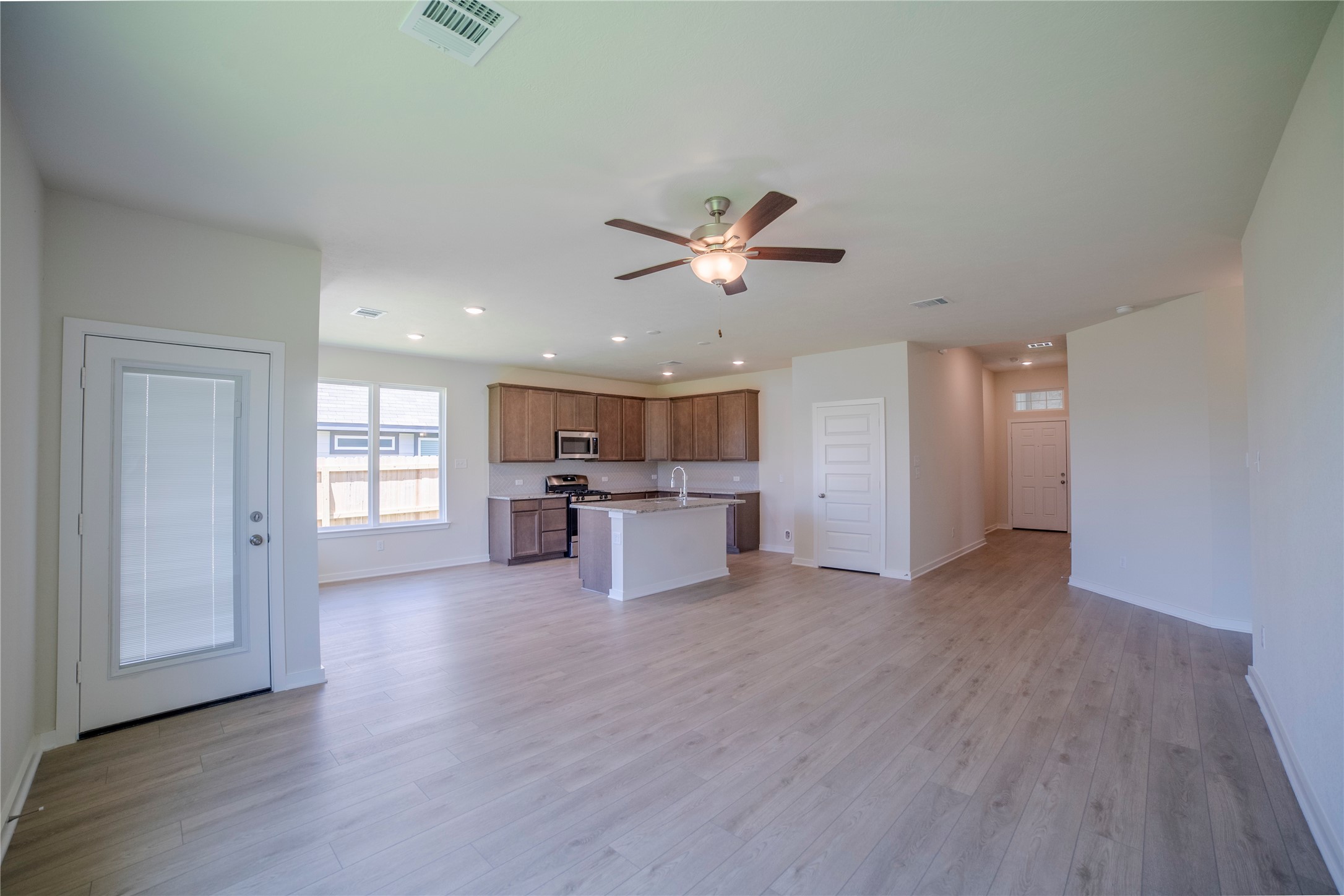 1402 Lk Rdg Drive Brenham, TX 77833 - Photo 18 of 35 a view of an empty room with a kitchen and wooden floor
