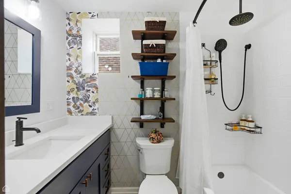 a bathroom with a sink a toilet and shower