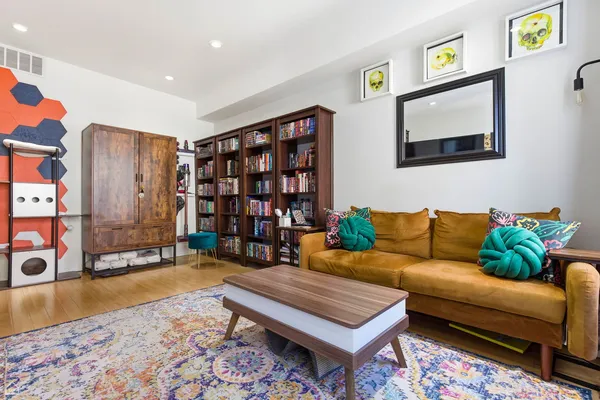 a living room with furniture a rug and a bookshelf