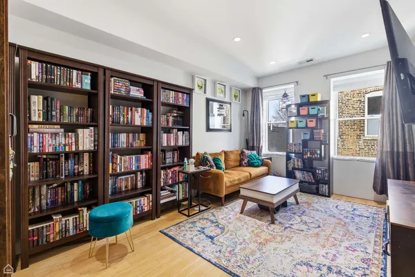 a living room with furniture and a book shelf