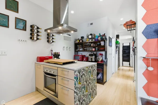 a kitchen that has a lot of cabinets a stove and a wooden floor
