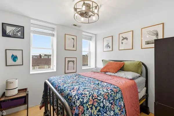 a bedroom with a bed and a chandelier
