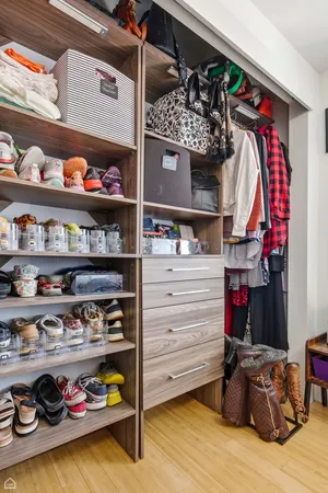 a view of walk in closet with clothes and shoes