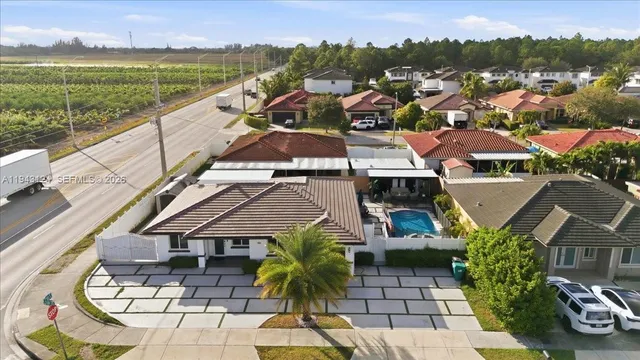 an aerial view of residential houses with outdoor space and trees