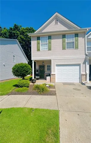 a view of a house with a yard and potted plants