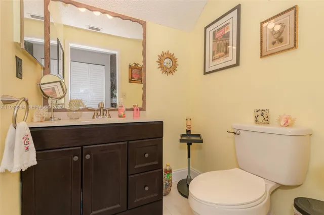 a bathroom with a sink vanity mirror and toilet