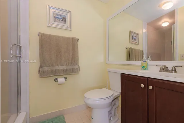 a bathroom with a toilet a sink a mirror a vanity and shower