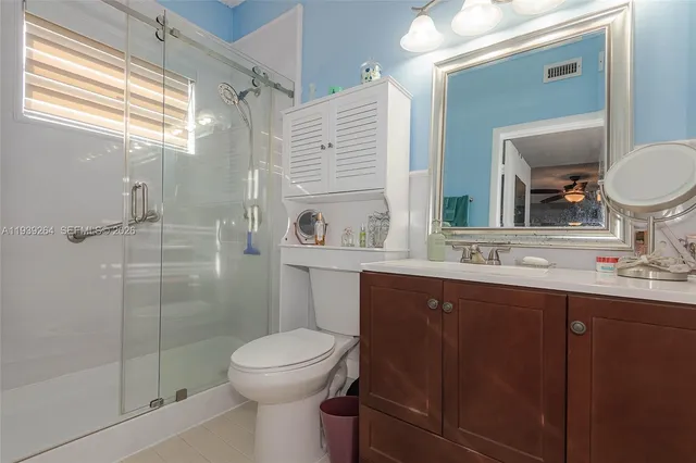 a bathroom with a sink toilet a mirror and shower
