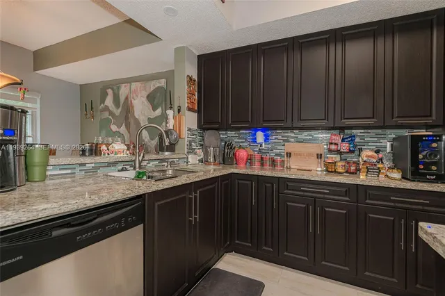 a kitchen with stainless steel appliances wooden cabinets sink and a counter top space