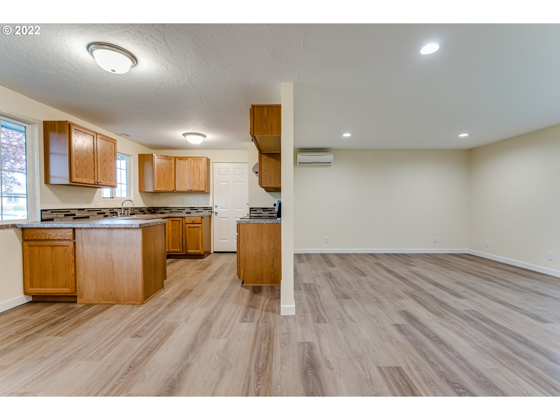 401 U Street Springfield, OR 97477 - Photo 9 of 29 a kitchen with stainless steel appliances granite countertop a stove a sink dishwasher and a microwave with wooden floor