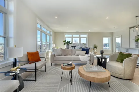 a living room with furniture a rug and a lamp
