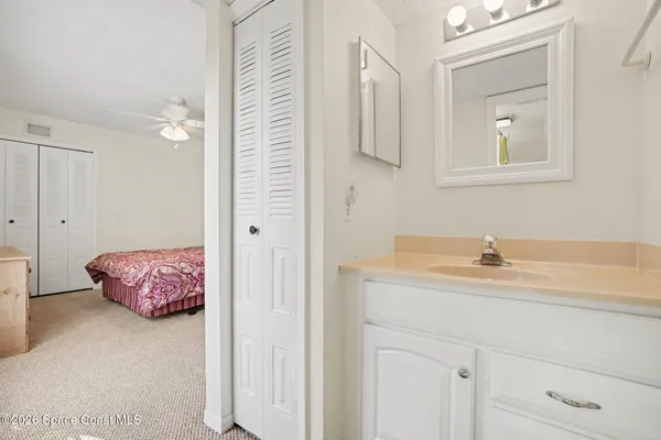 a en suite bathroom with a granite countertop sink and a mirror