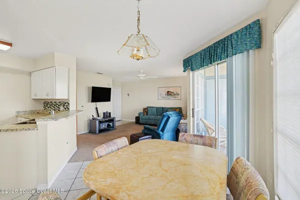 a living room with furniture a flat screen tv and kitchen view