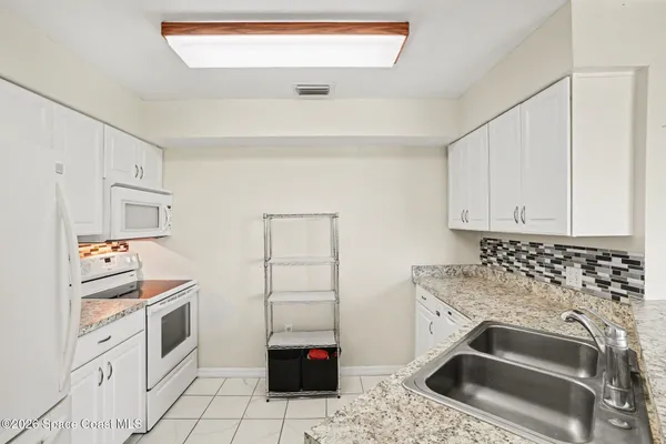 a kitchen with a stove and white cabinets