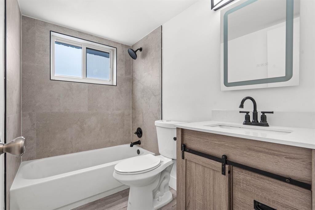 45 Northeast 24th Street, Unit B Wilton Manors, FL 33305 - Photo 11 of 19 a bathroom with a sink a toilet and shower