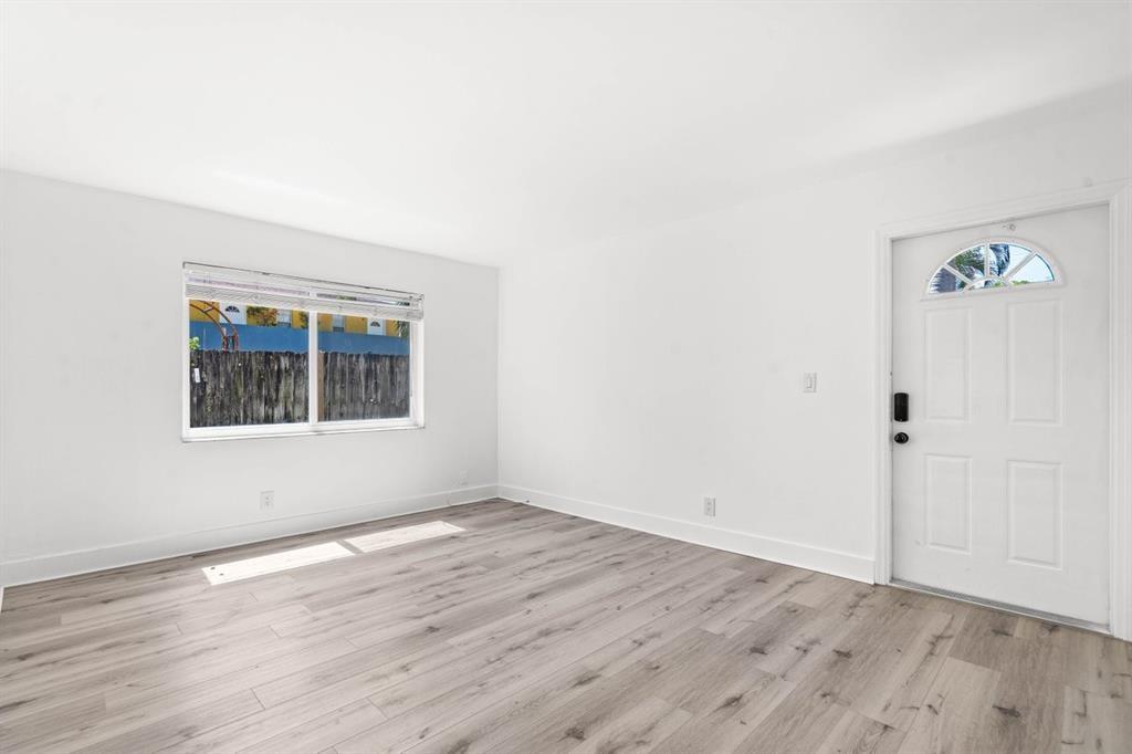 45 Northeast 24th Street, Unit B Wilton Manors, FL 33305 - Photo 5 of 19 an empty room with wooden floor and windows