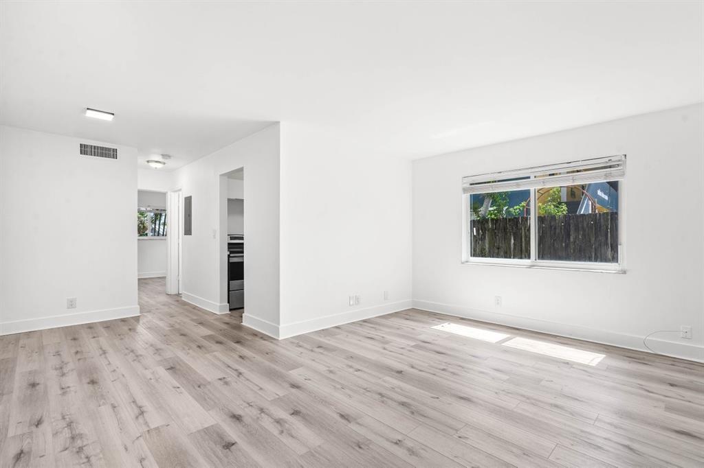 45 Northeast 24th Street, Unit B Wilton Manors, FL 33305 - Photo 6 of 19 a view of an empty room with wooden floor and a window