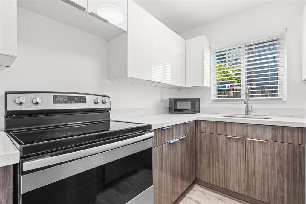 45 Northeast 24th Street, Unit B Wilton Manors, FL 33305 - Photo 9 of 19 a kitchen with a stove and a sink