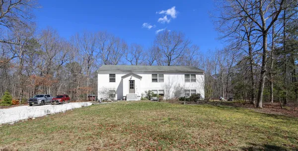 a view of a house with backyard and trees
