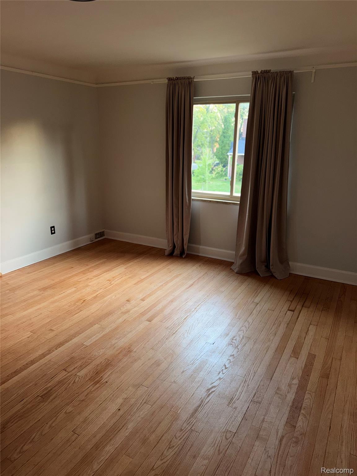 3914 Balfour Road Detroit, MI 48224 - Photo 21 of 24 Hardwood flooring, light neutral wall color, crown molding, and a window with trim
