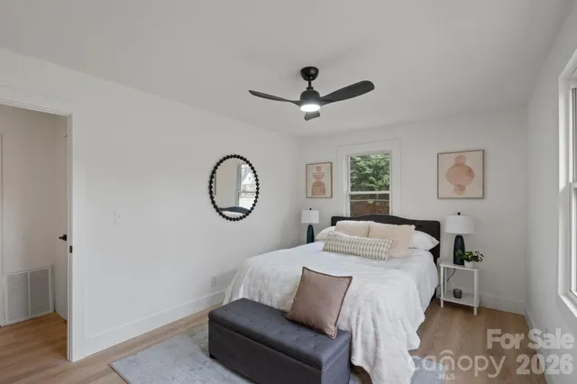 a bedroom with a bed a mirror and a window