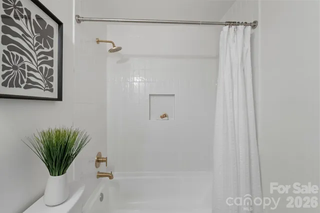 a bathroom with a shower curtain and a window