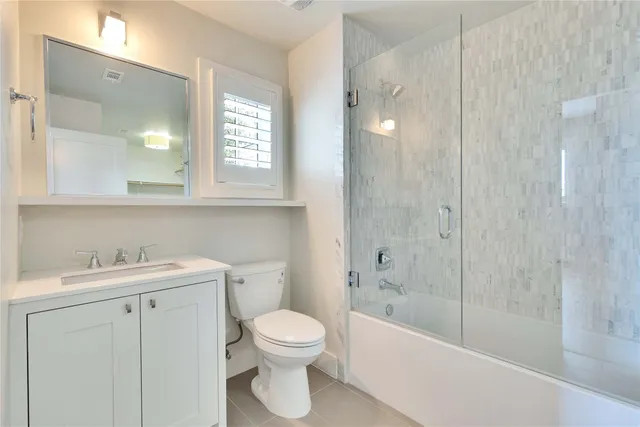 a bathroom with a bathtub shower sink vanity and toilet