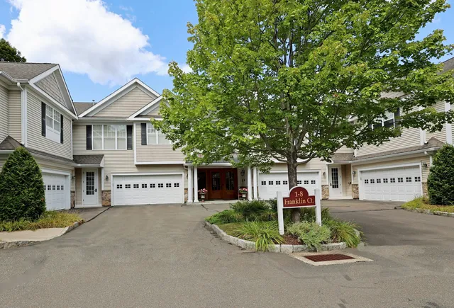 a front view of a house with a yard and trees