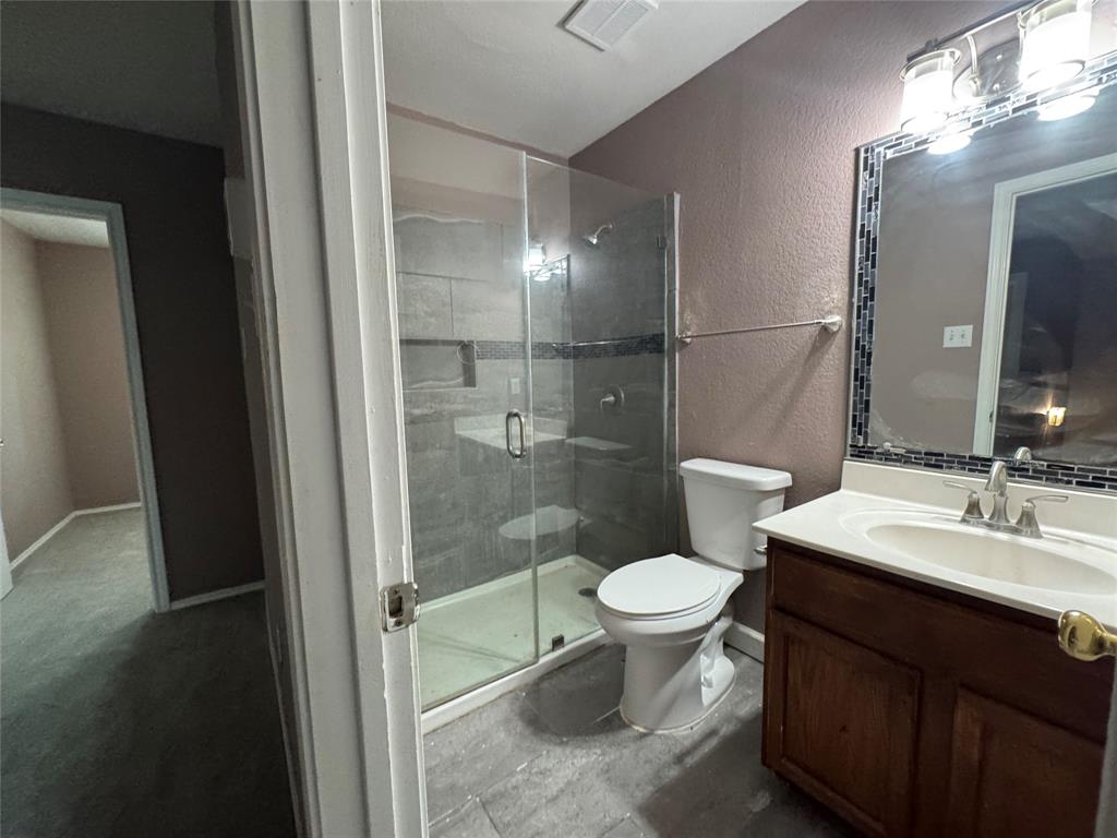 3200 Crownover Street Austin, TX 78725 - Photo 13 of 23 A streamlined modern bathroom features a glass-enclosed shower, a sleek vanity, and tiled floors.