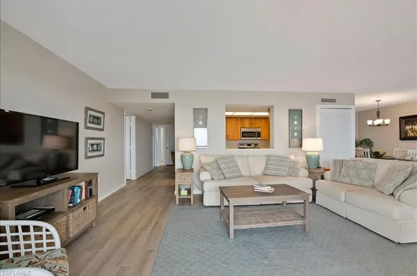 a living room with furniture a dining table and a wooden floor