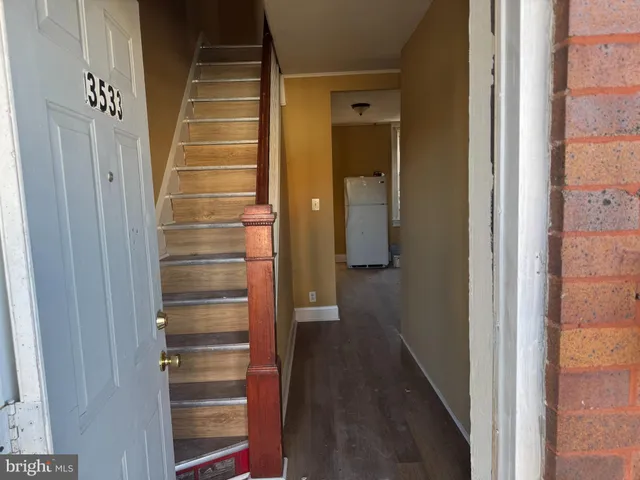 a view of a hallway with wooden floor and entryway