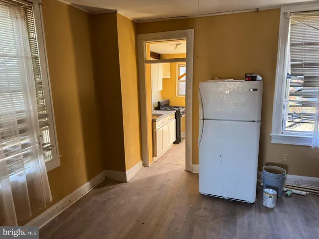 a kitchen with a refrigerator and wooden floor