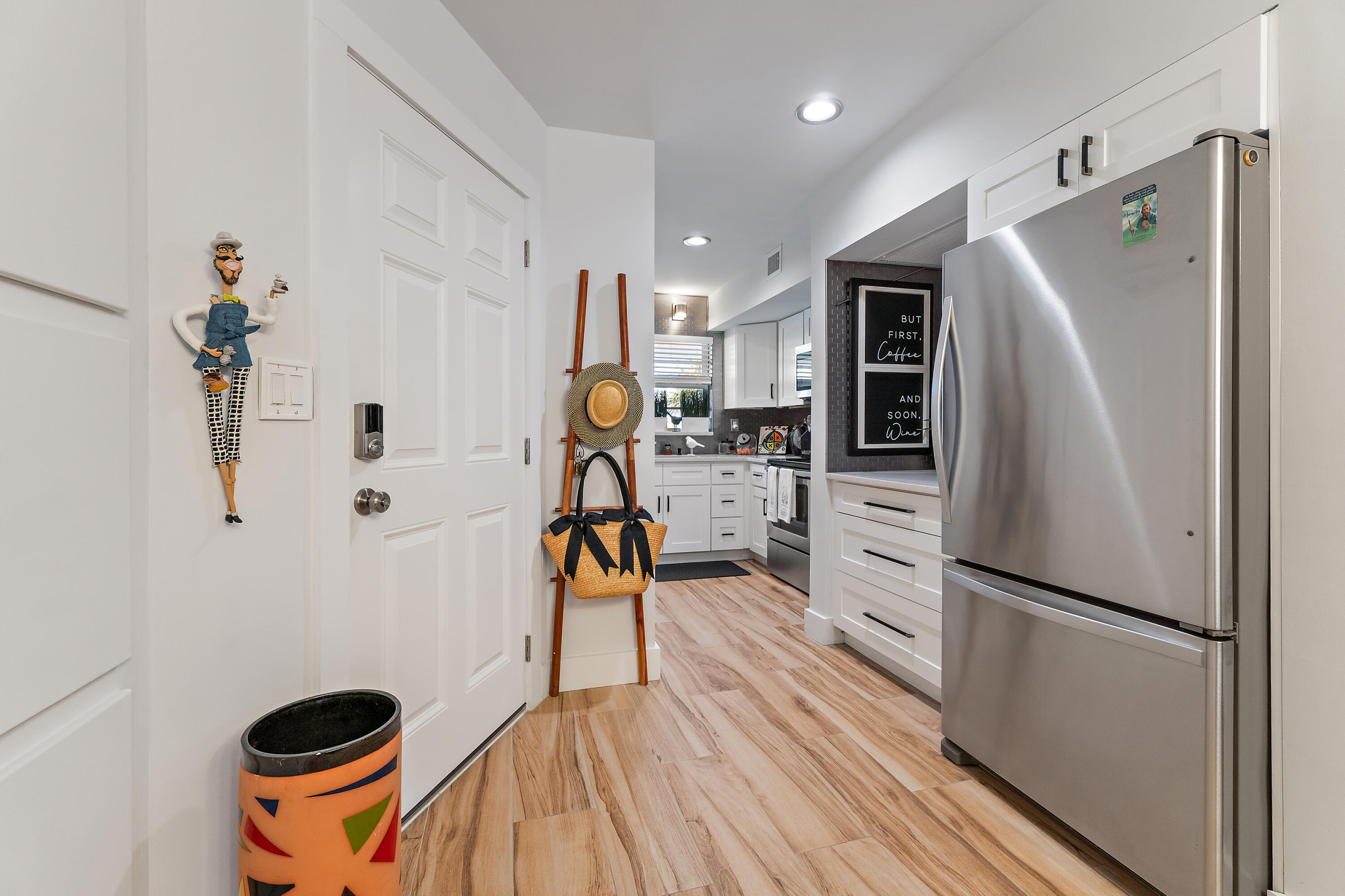50 Celestial Way, Unit 310 Juno Beach, FL 33408 - Photo 3 of 33 a kitchen with stainless steel appliances a refrigerator a stove a sink dishwasher and a stove with wooden floor