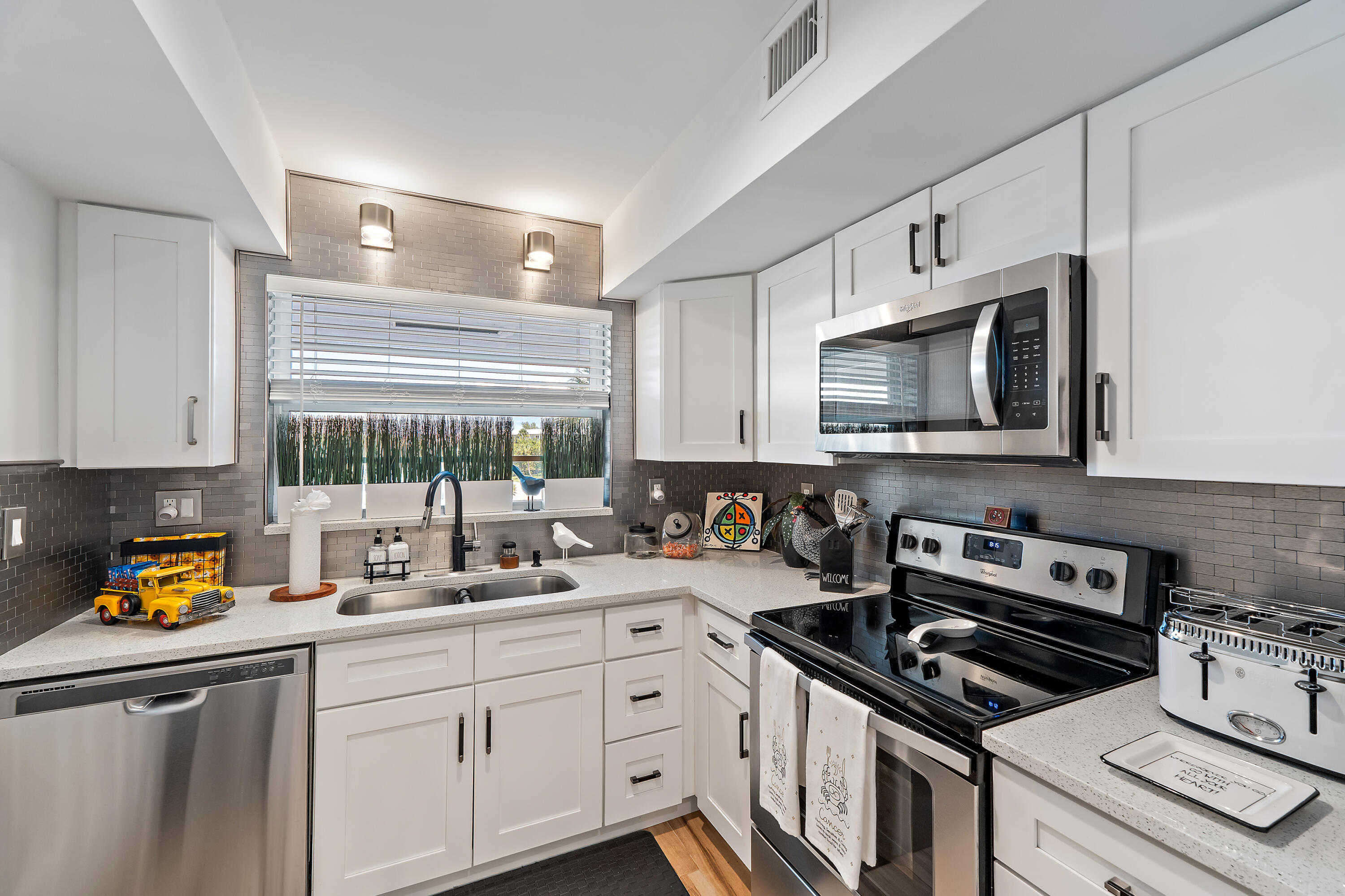 50 Celestial Way, Unit 310 Juno Beach, FL 33408 - Photo 5 of 33 a kitchen with stainless steel appliances a sink a stove a microwave and cabinets