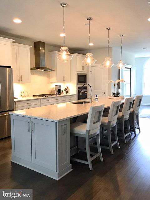 22283 Philanthropic Drive Ashburn, VA 20148 - Photo 6 of 17 a kitchen with stainless steel appliances kitchen island granite countertop a table chairs sink and cabinets