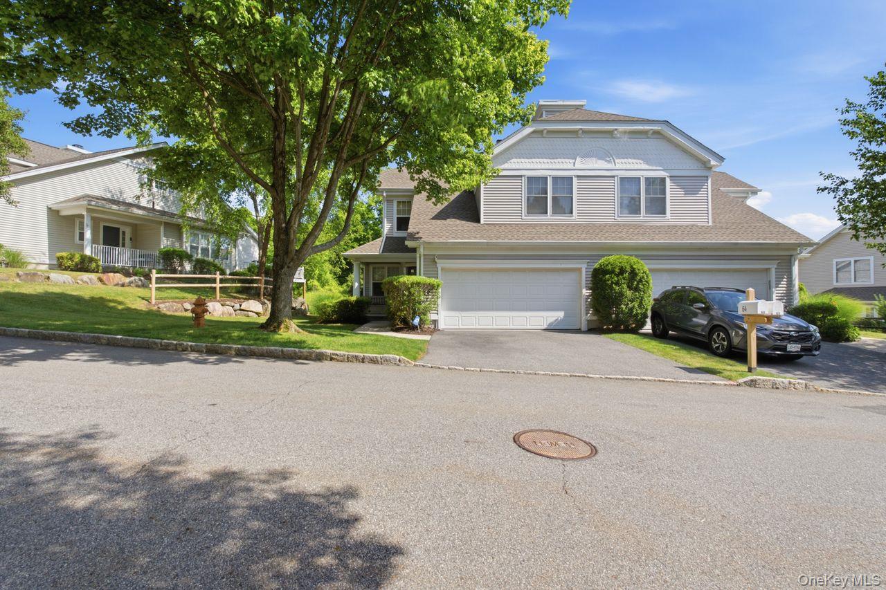 64 Roma Orchard Road Peekskill, NY 10566 - Photo 2 of 40 Contemporary exterior featuring light grey siding, a two-car garage, and a sloped driveway