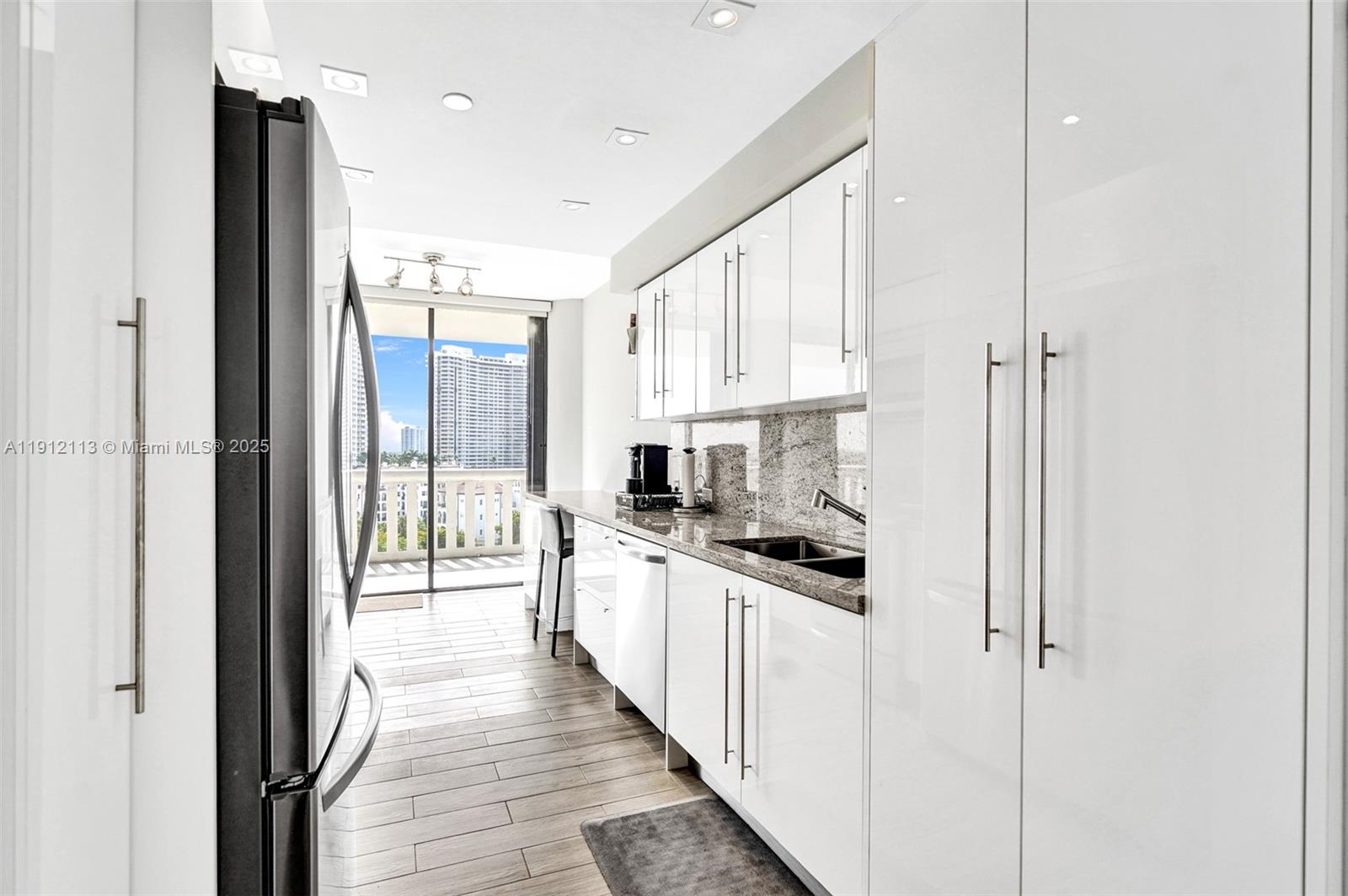 a kitchen with stainless steel appliances a refrigerator sink and white cabinets
