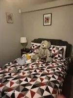 a bedroom with a bed and a lamp on the dresser