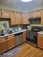 a kitchen with a sink a stove cabinets and wooden floor