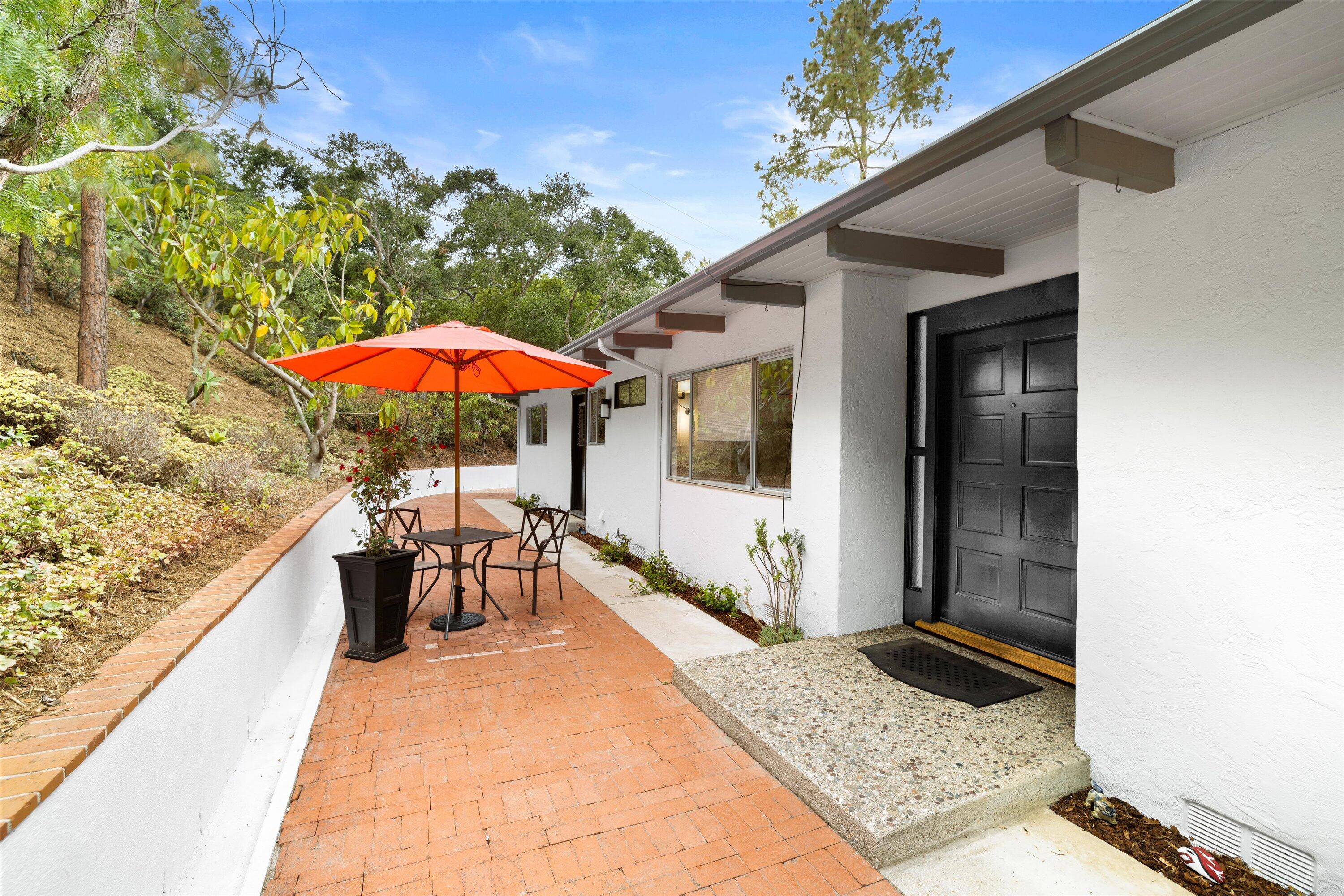 870 Arcady Road Montecito, CA 93108 - Photo 3 of 32 a view of a patio with a table and chairs under an umbrella with a small yard