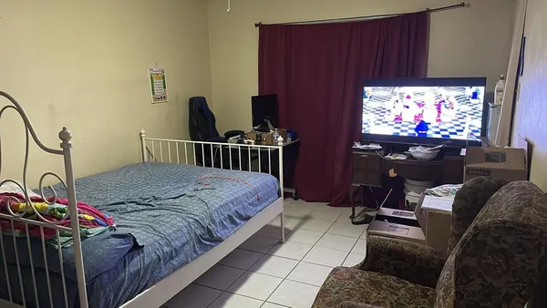 a bedroom with bed and a flat screen tv