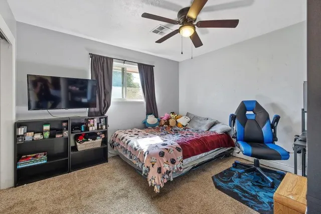 a bed room with a bed furniture and a flat tv screen